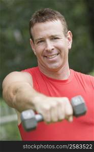 Portrait of a mature man exercising with a dumbbell