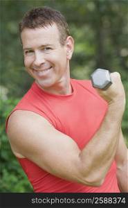 Portrait of a mature man exercising with a dumbbell