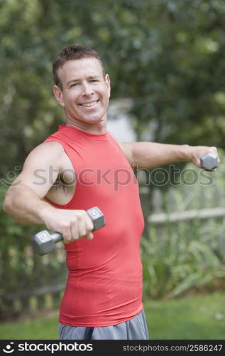 Portrait of a mature man exercising with dumbbells