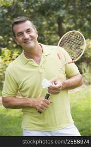 Portrait of a mature man holding a badminton racket and a shuttlecock