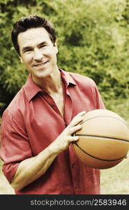 Portrait of a mature man holding a basketball