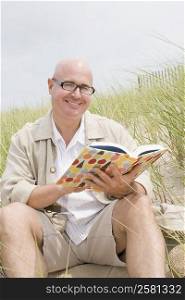 Portrait of a mature man holding a book and smiling