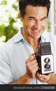 Portrait of a mature man holding a camera