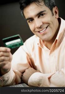Portrait of a mature man holding a credit card and smiling