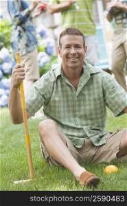 Portrait of a mature man holding a croquet mallet and smiling