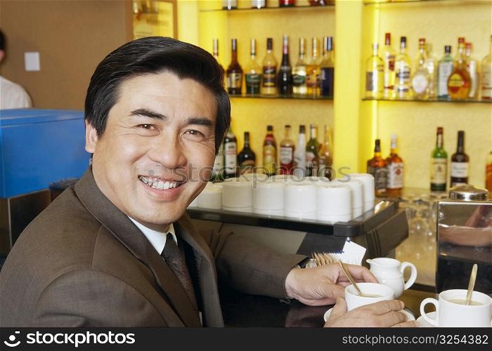 Portrait of a mature man holding a cup of coffee in a restaurant