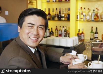 Portrait of a mature man holding a cup of coffee in a restaurant