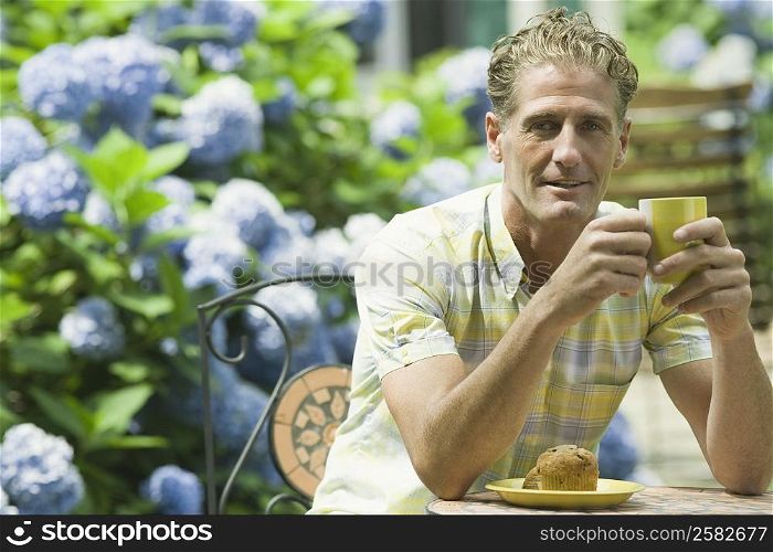 Portrait of a mature man holding a cup of tea and smiling