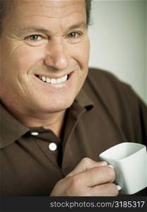 Portrait of a mature man holding a cup of tea and smiling