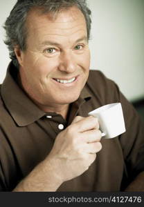 Portrait of a mature man holding a cup of tea and smiling