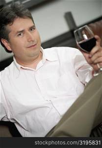 Portrait of a mature man holding a glass of red wine