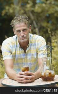 Portrait of a mature man holding a glass of soda