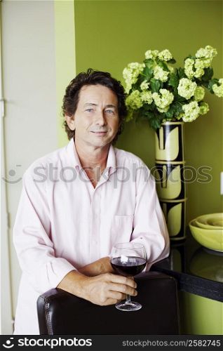 Portrait of a mature man holding a glass of wine