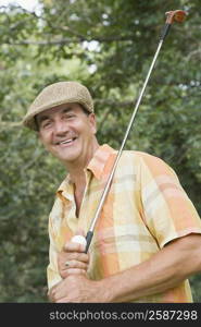 Portrait of a mature man holding a golf club and a golf ball