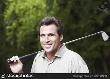 Portrait of a mature man holding a golf club and smiling
