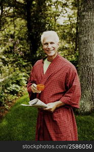 Portrait of a mature man holding a newspaper and a cup of tea