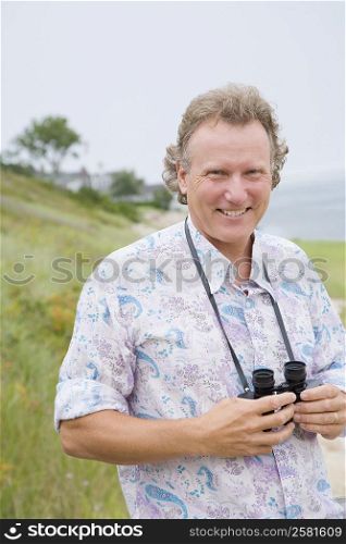 Portrait of a mature man holding a pair of binoculars