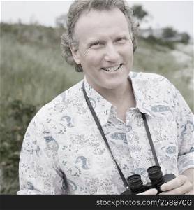 Portrait of a mature man holding a pair of binoculars