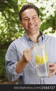 Portrait of a mature man holding a pitcher of lemonade