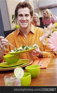 Portrait of a mature man holding a plate of salad and smiling
