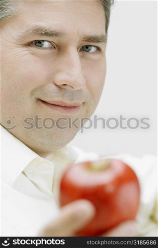 Portrait of a mature man holding an apple