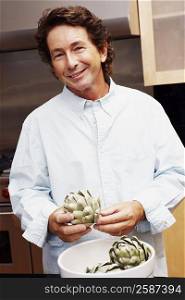 Portrait of a mature man holding an artichoke