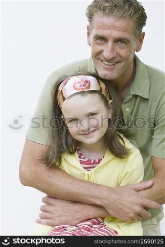 Portrait of a mature man hugging his daughter and smiling