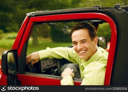 Portrait of a mature man in a driver seat of a car and smiling