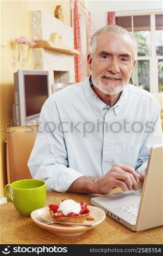 Portrait of a mature man in front of a laptop