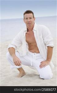 Portrait of a mature man kneeling on the beach