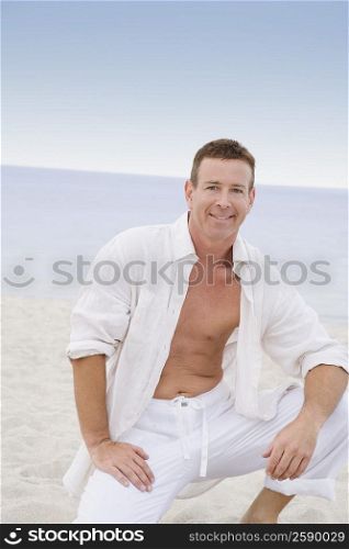 Portrait of a mature man kneeling on the beach