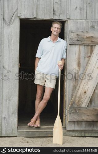 Portrait of a mature man leaning against the door of a beach hut