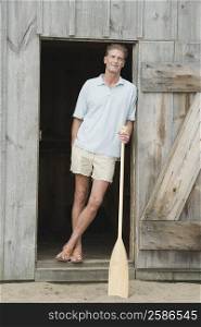 Portrait of a mature man leaning against the door of a beach hut