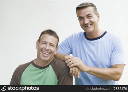 Portrait of a mature man leaning on his brother&acute;s shoulder and smiling