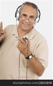 Portrait of a mature man listening to an MP3 player