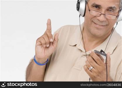 Portrait of a mature man listening to an MP3 player