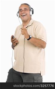 Portrait of a mature man listening to an MP3 player and laughing