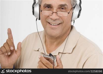 Portrait of a mature man listening to an MP3 player and singing