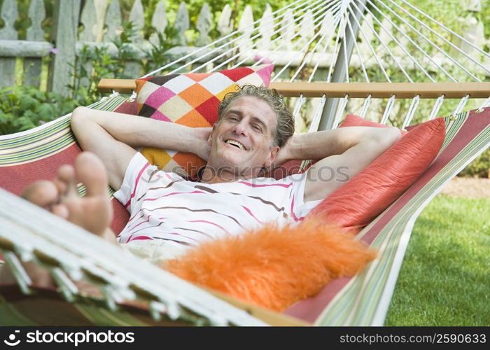 Portrait of a mature man lying in a hammock and smiling
