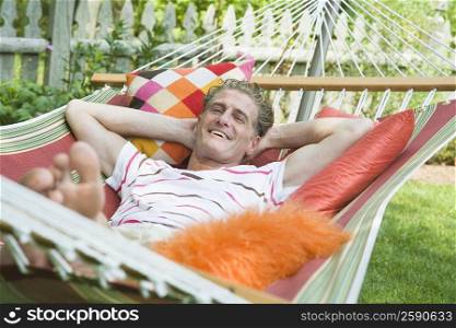 Portrait of a mature man lying in a hammock and smiling
