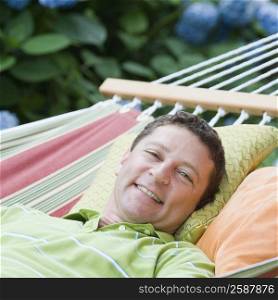 Portrait of a mature man lying on a hammock and smiling