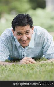 Portrait of a mature man lying on grass and smiling