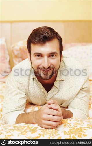 Portrait of a mature man lying on the bed and smiling