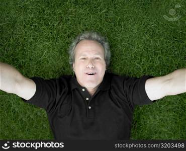 Portrait of a mature man lying on the grass and smiling