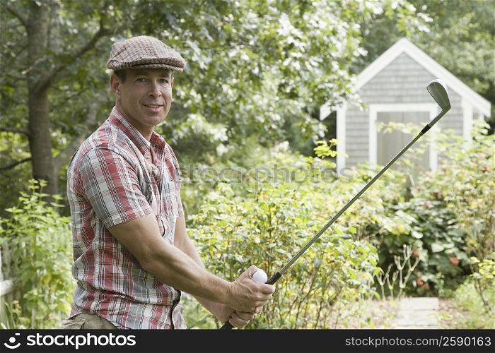 Portrait of a mature man playing golf in a garden