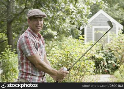 Portrait of a mature man playing golf in a garden