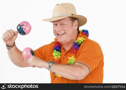 Portrait of a mature man playing maracas and smiling
