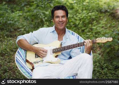 Portrait of a mature man playing the guitar
