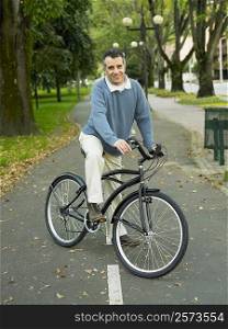 Portrait of a mature man riding a bicycle in the park