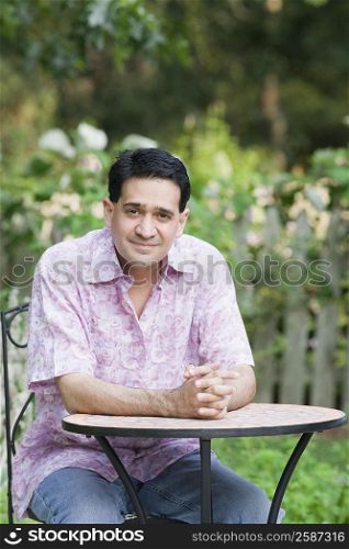 Portrait of a mature man sitting at a table and smiling